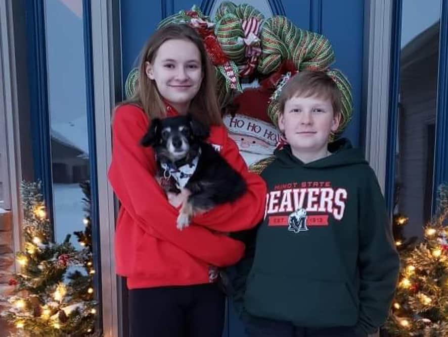 two teens standing in front of a dog holding dog. - testimonial for Melinda S.
