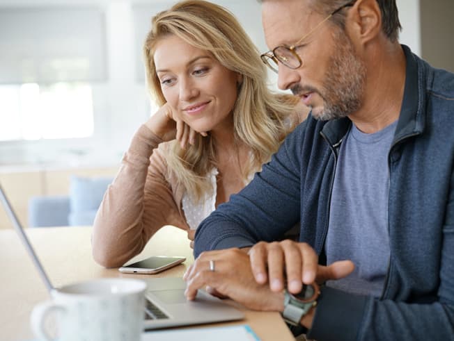 Middle age couple doing reasearch on computer