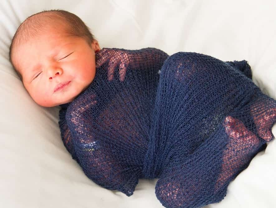 baby wrapped in blue blanket - testimonial for Leslea Z.